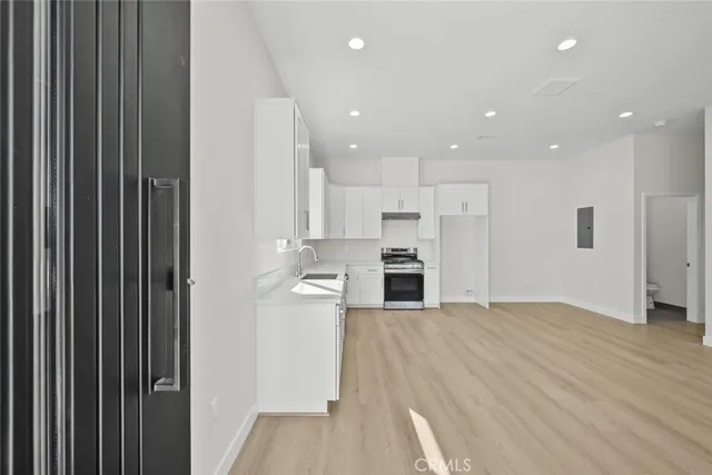 a large kitchen with stainless steel appliances granite countertop a stove a sink and a refrigerator