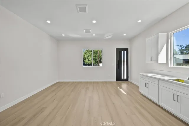 a kitchen with white cabinets appliances and sink