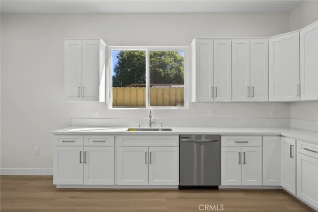 a kitchen with a sink cabinets stainless steel appliances and a window