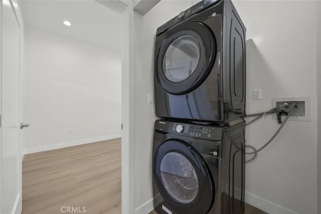 a view of an empty room with wooden floor and closet