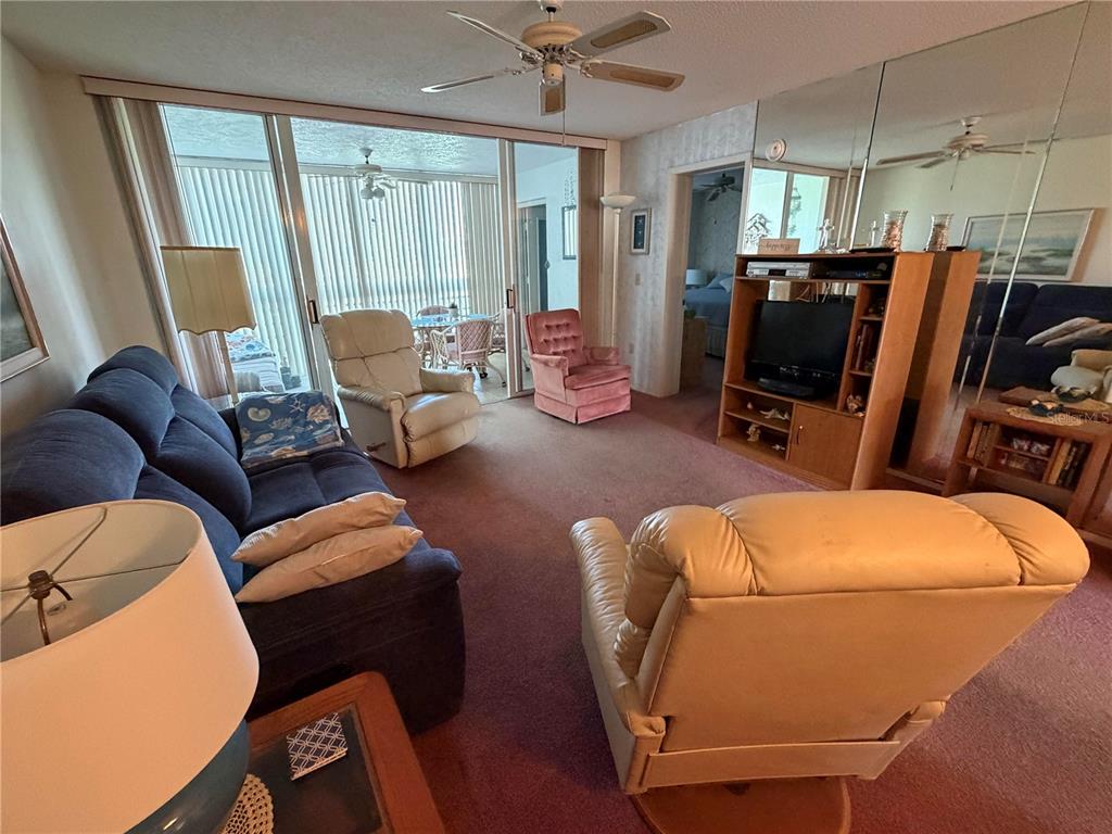 4570 Pinebrook Circle, Unit 204 Bradenton, FL 34209 - Photo 5 of 12 a living room with furniture a ceiling fan and a window