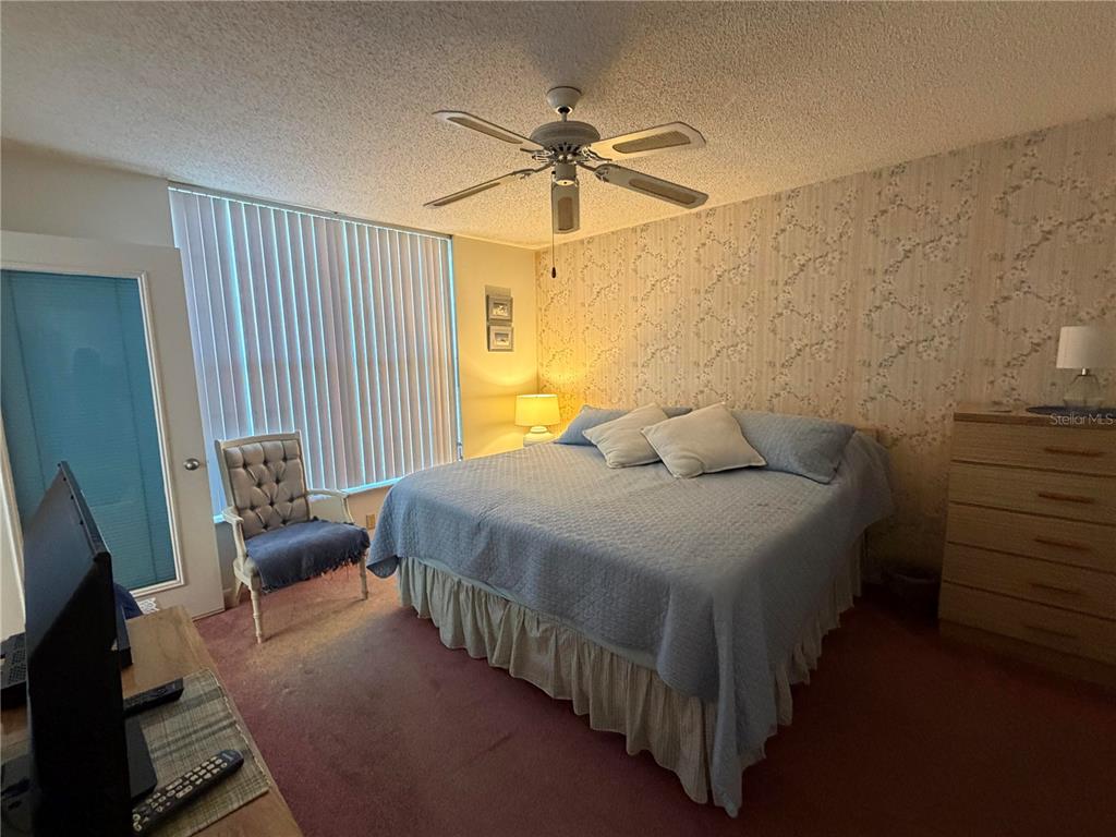 4570 Pinebrook Circle, Unit 204 Bradenton, FL 34209 - Photo 6 of 12 a bedroom with a bed and a chandelier