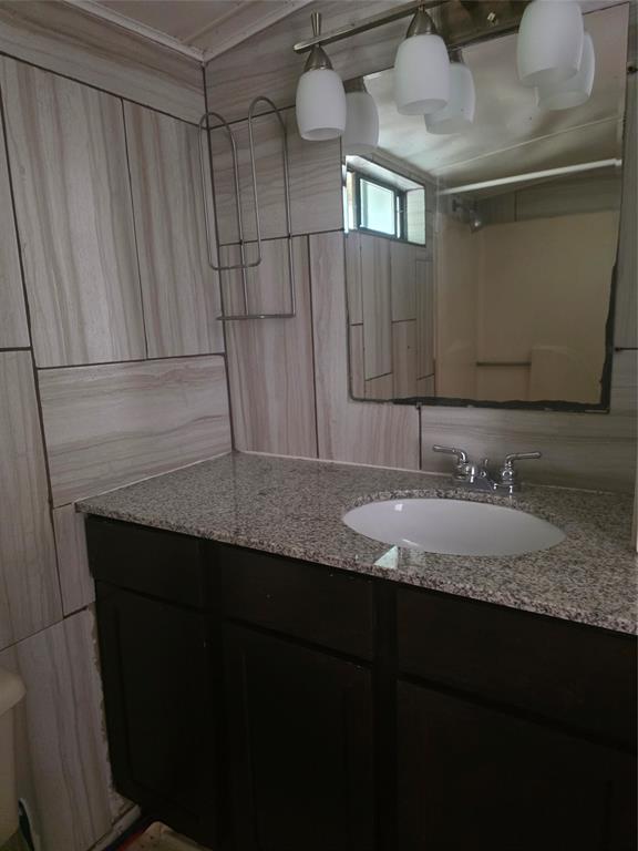1106 6th Street Southeast Paris, TX 75460 - Photo 2 of 12 a bathroom with a granite countertop sink and a mirror