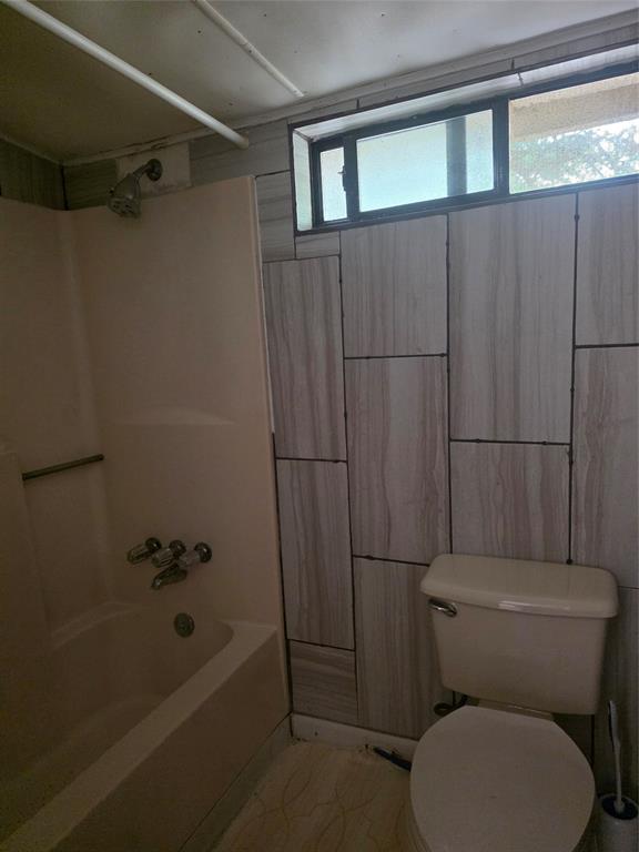 1106 6th Street Southeast Paris, TX 75460 - Photo 4 of 12 a white toilet sitting next to a bath tub