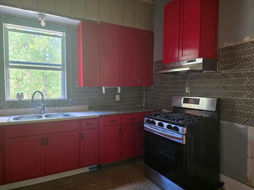1106 6th Street Southeast Paris, TX 75460 - Photo 8 of 12 a kitchen with stainless steel appliances a stove a sink and a microwave