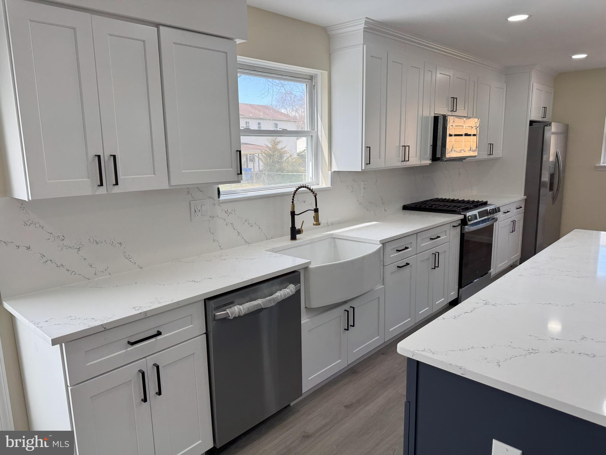 906 Marlowe Road Cherry Hill, NJ 08003 - Photo 11 of 38 a kitchen with kitchen island granite countertop a sink white cabinets and stainless steel appliances