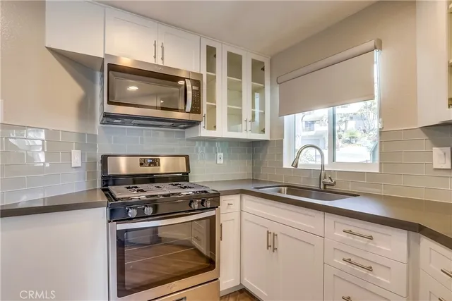 a kitchen with stainless steel appliances a refrigerator stove microwave and sink