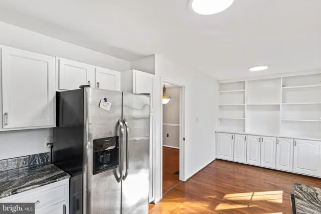 a kitchen with white cabinets and refrigerator