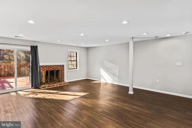 an empty room with wooden floor and fireplace