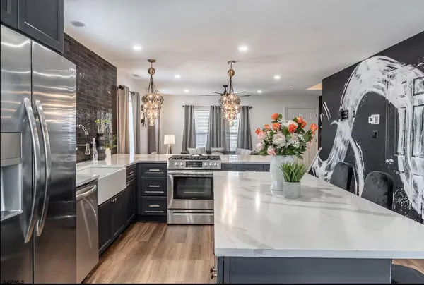 a kitchen with stainless steel appliances granite countertop a sink and a refrigerator
