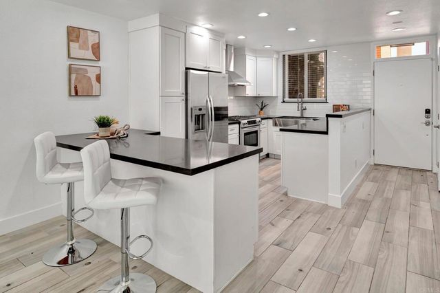 a view of entryway and kitchen with wooden floor