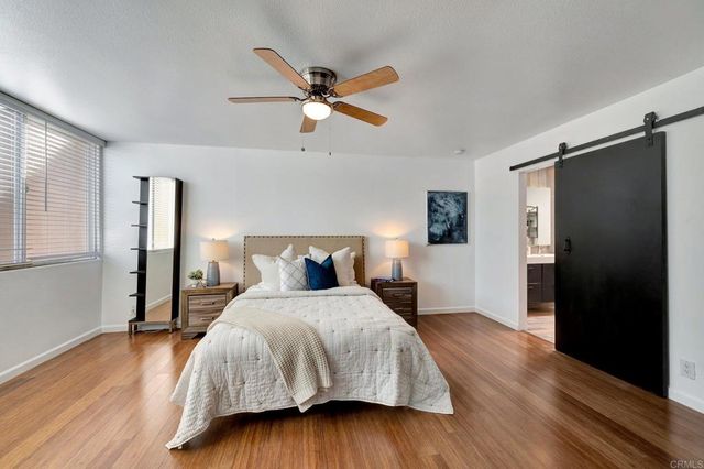a view of a room with wooden floor and a ceiling fan