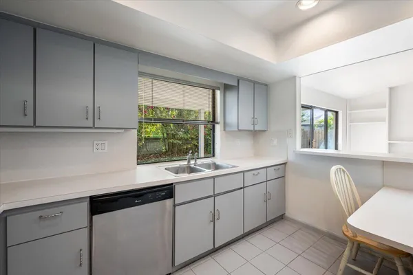 a kitchen with white cabinets stainless steel appliances and a sink
