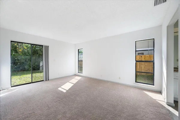 a view of an empty room with closet and a window