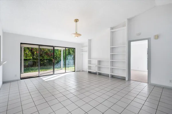 an empty room with entrance and windows