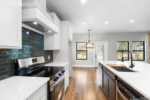 a kitchen with a sink a stove and cabinets
