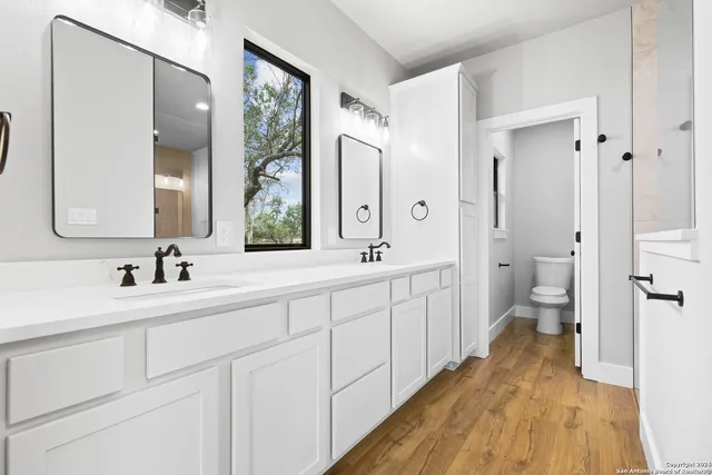 a spacious bathroom with a double vanity sink and mirror