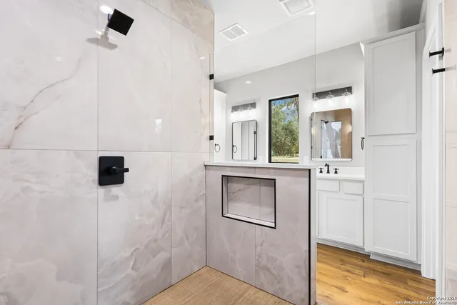 a bathroom with a sink a mirror and shower