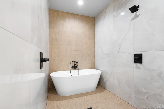 a white bath tub sitting next to a white sink
