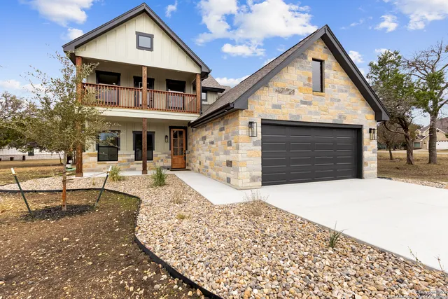 a front view of a house with a yard outdoor seating and garage