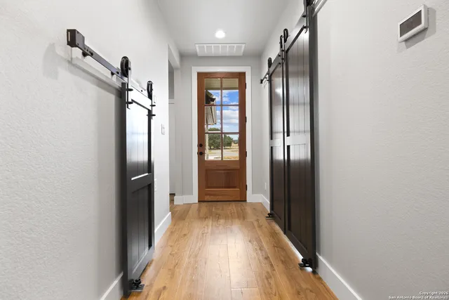 a view of a hallway with wooden floor and staircase