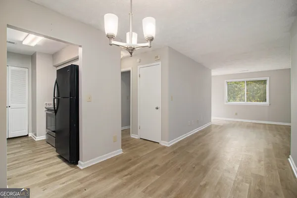 a view of a room with wooden floor chandelier and windows