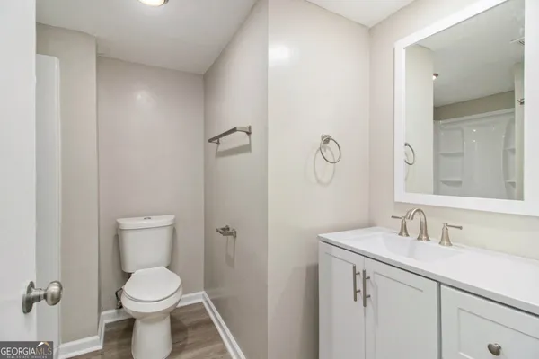 a bathroom with a toilet sink and mirror