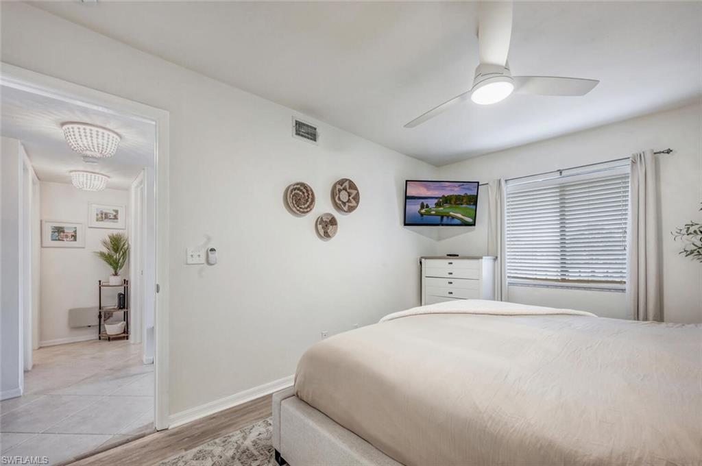7300 St Ives Way, Unit 5208 Naples, FL 34104 - Photo 17 of 37 a bedroom with a large bed and a window