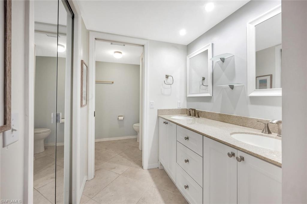 7300 St Ives Way, Unit 5208 Naples, FL 34104 - Photo 19 of 37 a spacious bathroom with a granite countertop sink mirror and double