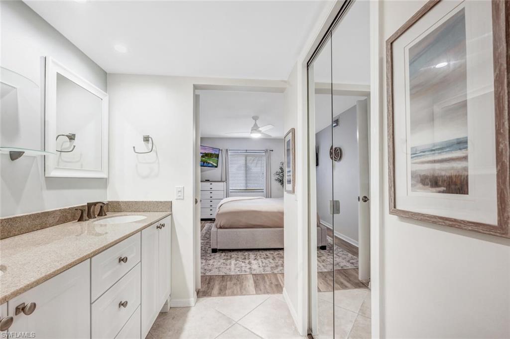 7300 St Ives Way, Unit 5208 Naples, FL 34104 - Photo 20 of 37 a en suite bathroom with a sink double vanity and shower