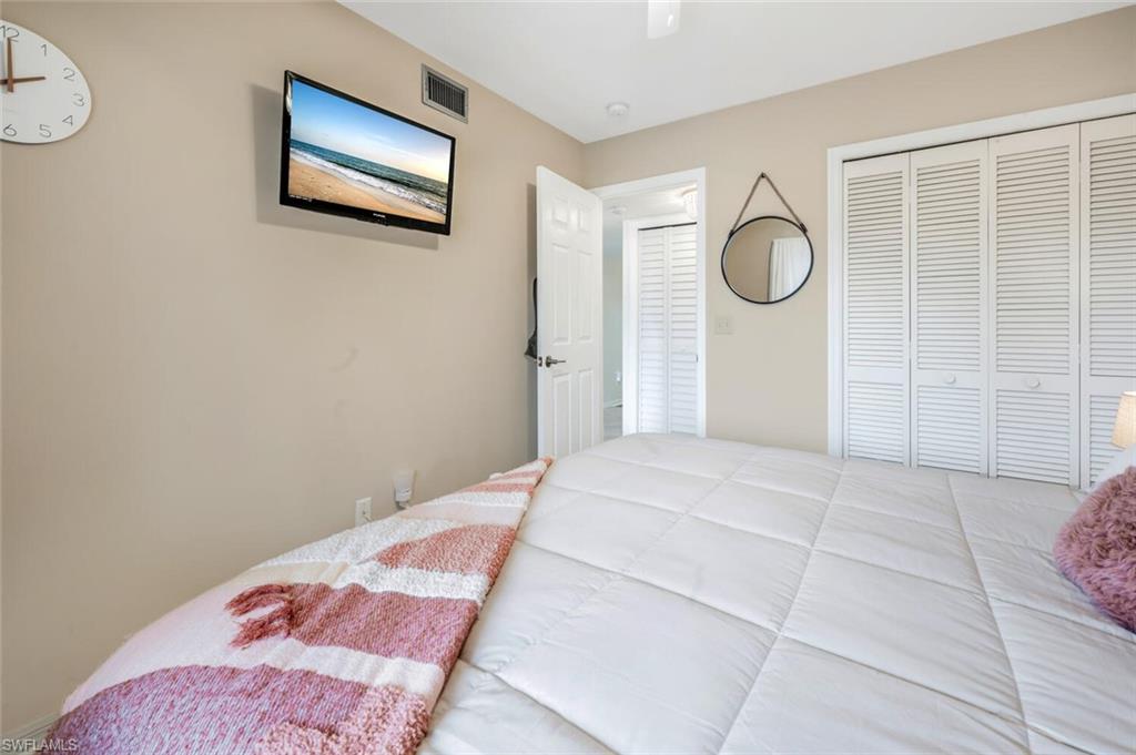 7300 St Ives Way, Unit 5208 Naples, FL 34104 - Photo 23 of 37 a bedroom with a bed and wooden floor