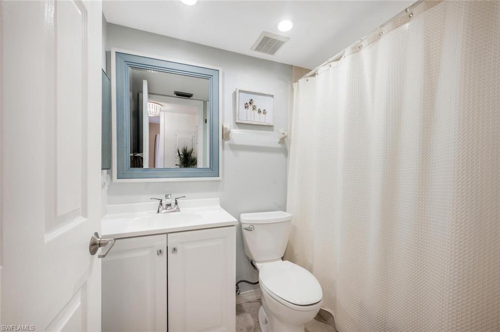7300 St Ives Way, Unit 5208 Naples, FL 34104 - Photo 24 of 37 a bathroom with a toilet sink and mirror