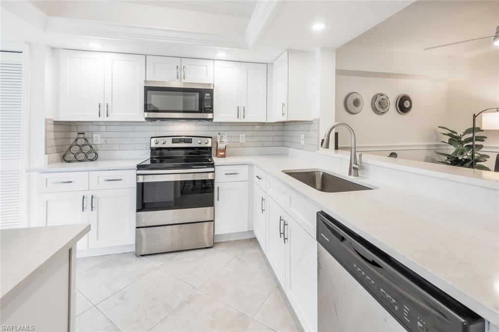 7300 St Ives Way, Unit 5208 Naples, FL 34104 - Photo 9 of 37 a kitchen with a sink stove and microwave
