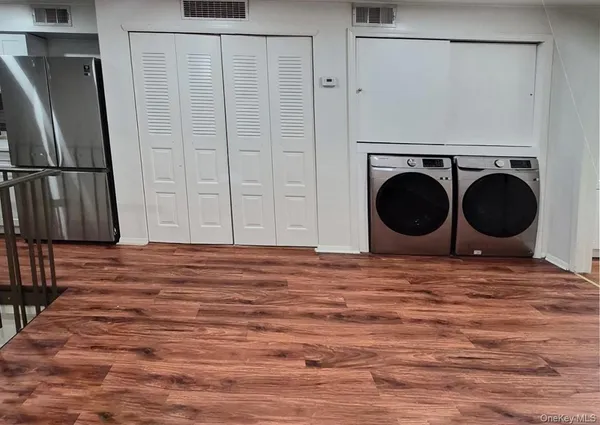 a view of a kitchen with a washer dryer and wooden floor