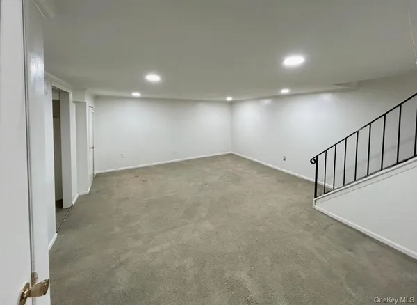 an empty room with wooden stairs and windows