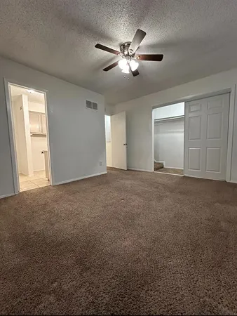 a view of an empty room with a ceiling fan