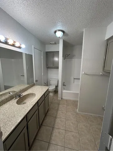 a bathroom with a granite countertop sink a large mirror and a shower