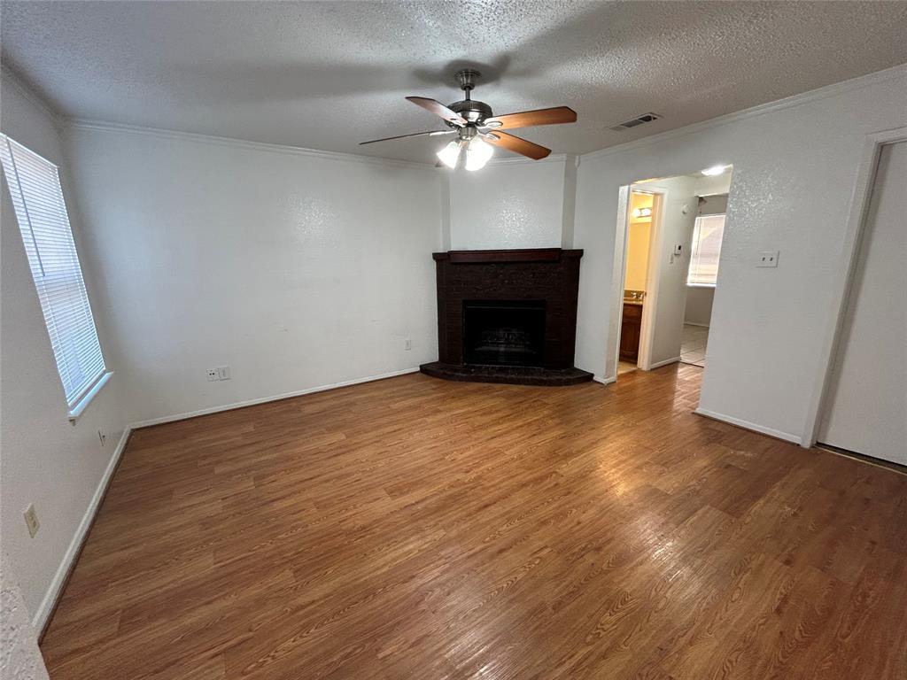 3006 West Sycamore Circle Euless, TX 76040 - Photo 2 of 16 an empty room with wooden floor fan and windows