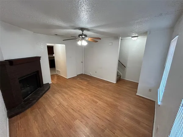 an empty room with wooden floor and fireplace