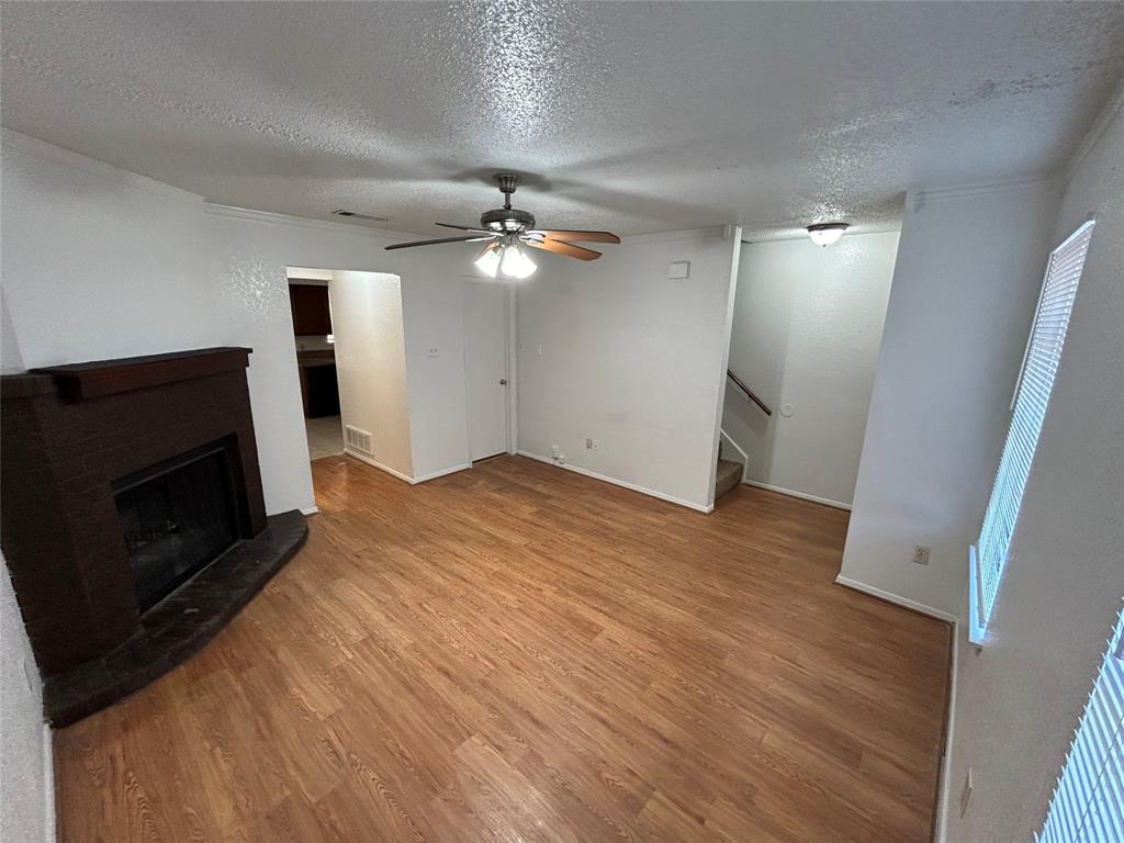 3006 West Sycamore Circle Euless, TX 76040 - Photo 3 of 16 an empty room with wooden floor and fireplace