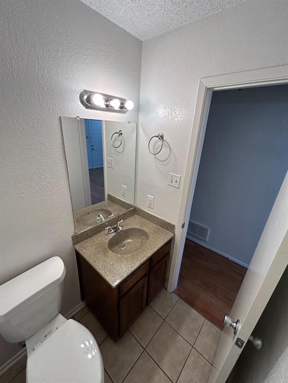 3006 West Sycamore Circle Euless, TX 76040 - Photo 7 of 16 a bathroom with a sink a toilet and mirror