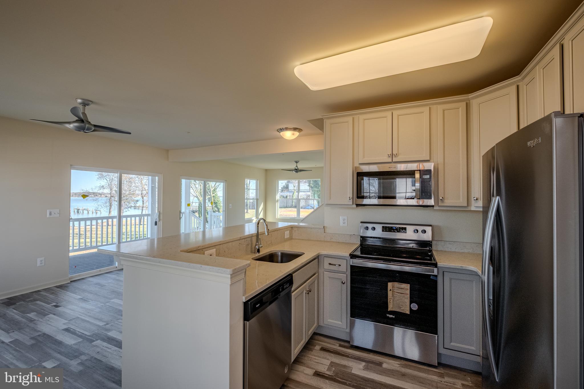 7391 Benedict Avenue Benedict, MD 20612 - Photo 11 of 38 a kitchen with stainless steel appliances a stove a sink a microwave a refrigerator and cabinets