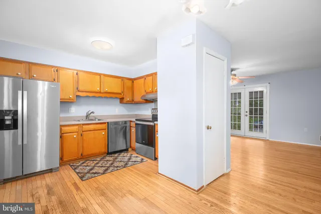 a kitchen with stainless steel appliances granite countertop a refrigerator and a stove top oven