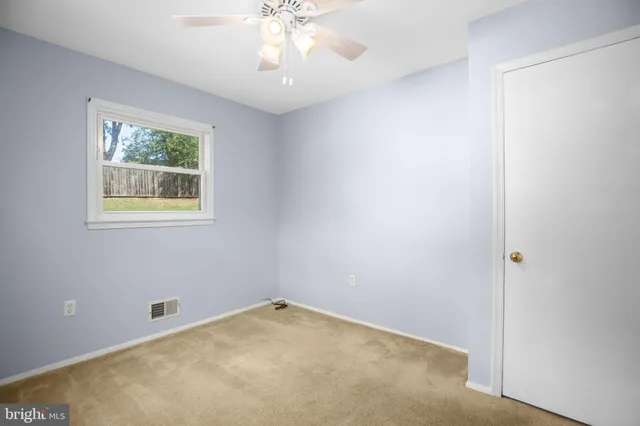 an empty room with a chandelier fan