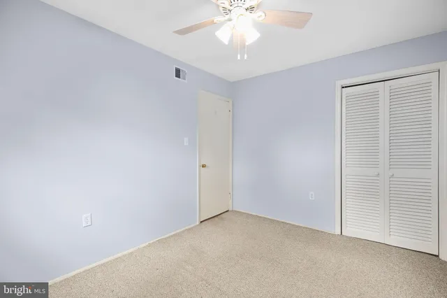 an empty room with a chandelier fan