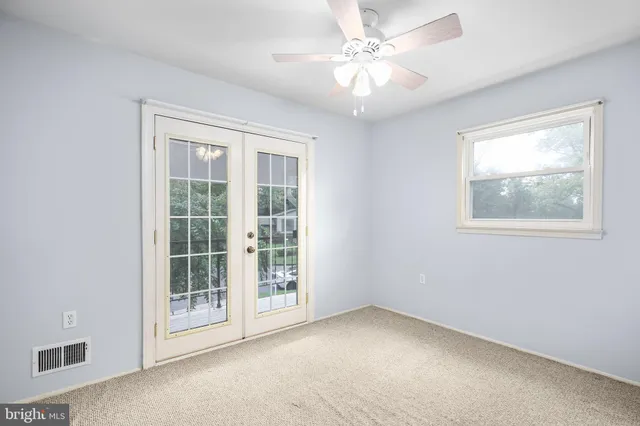 an empty room with windows and fan
