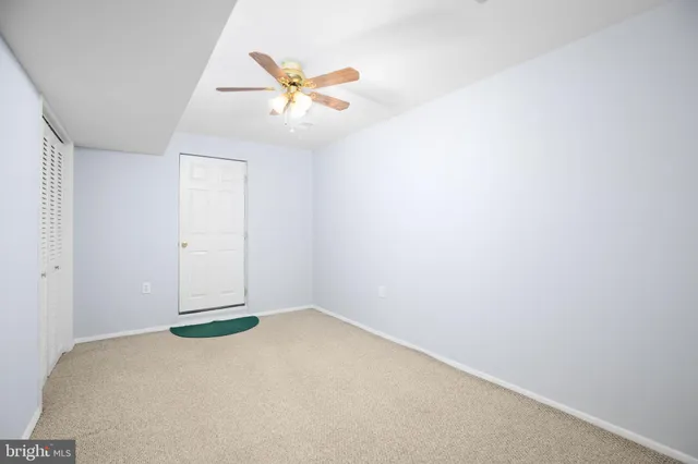 an empty room with closet and fan