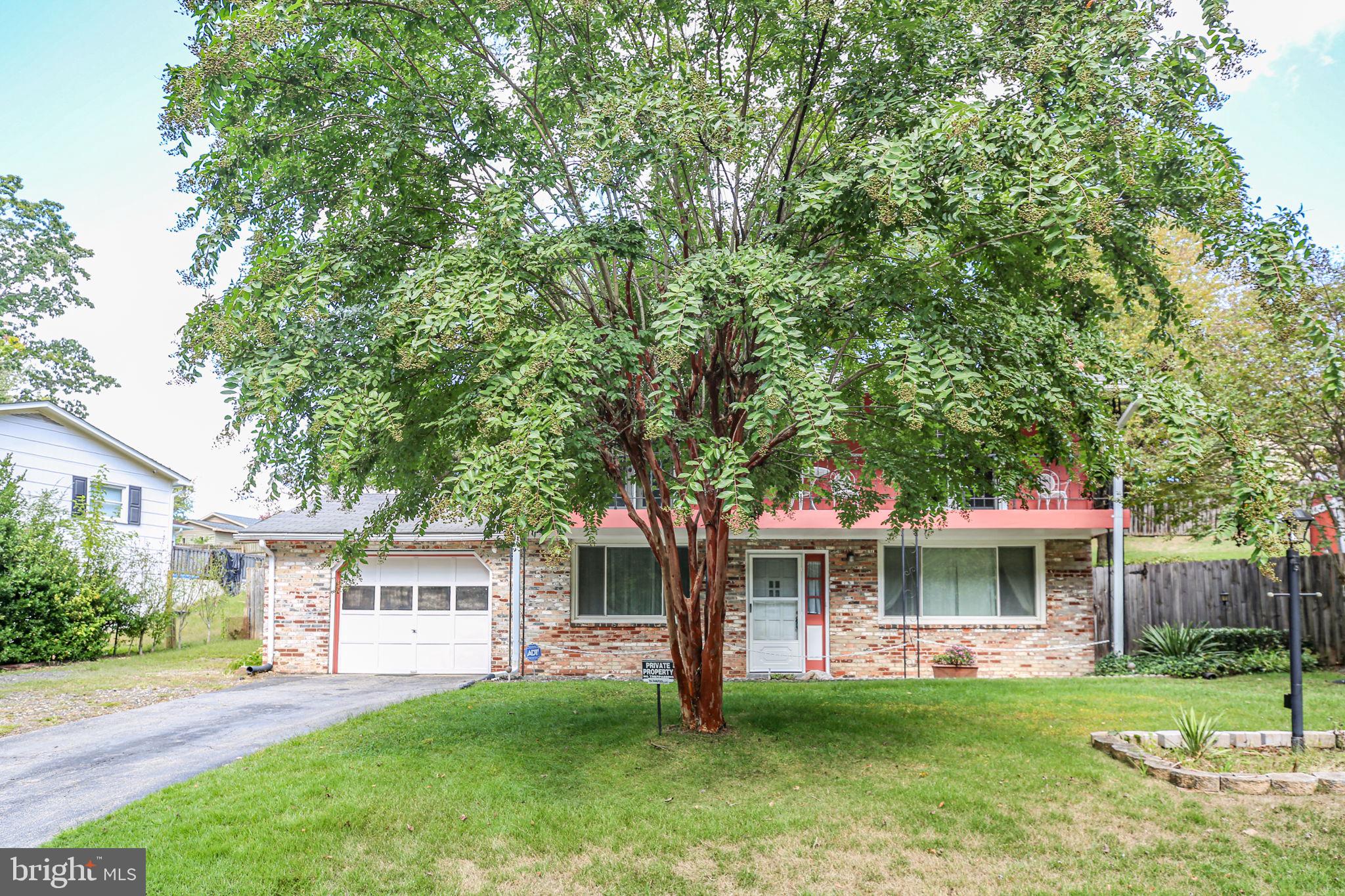 19007 Red Oak Lane Triangle, VA 22172 - Photo 33 of 34 a front view of a house with a garden and trees