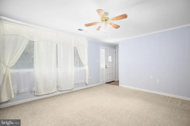 an empty room with a window and ceiling fan