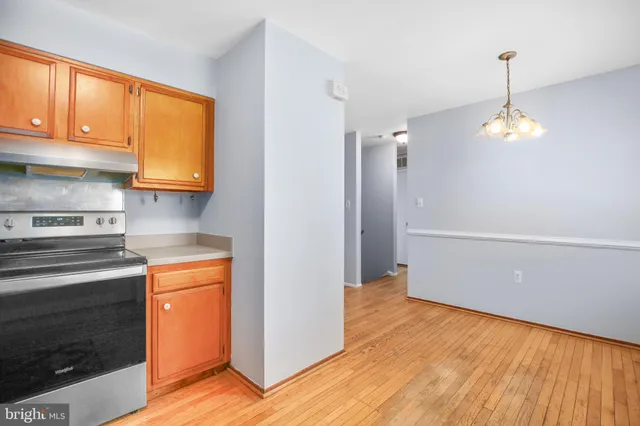 a kitchen with stainless steel appliances granite countertop a refrigerator a stove and a wooden floors